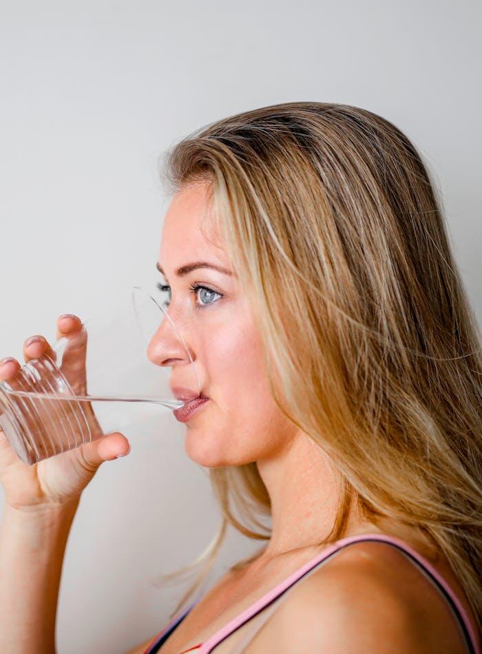 Donna che beve acqua pura